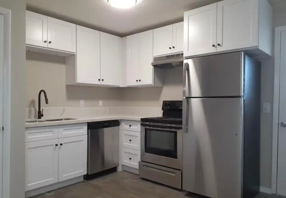 Interior kitchen with stainless appliances (fridge, stove, dishwasher) and white cabinets inside Terra at Ashley apartments