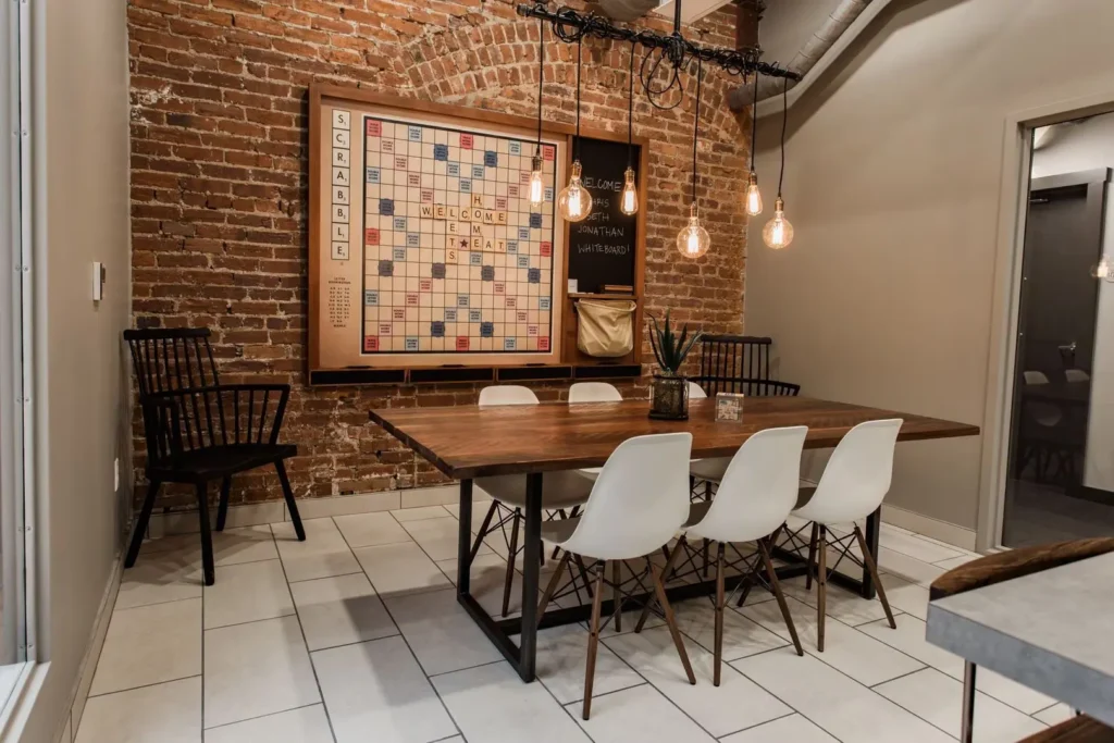 Tomorrow building interior shared kitchen with table and scrabble board on wall