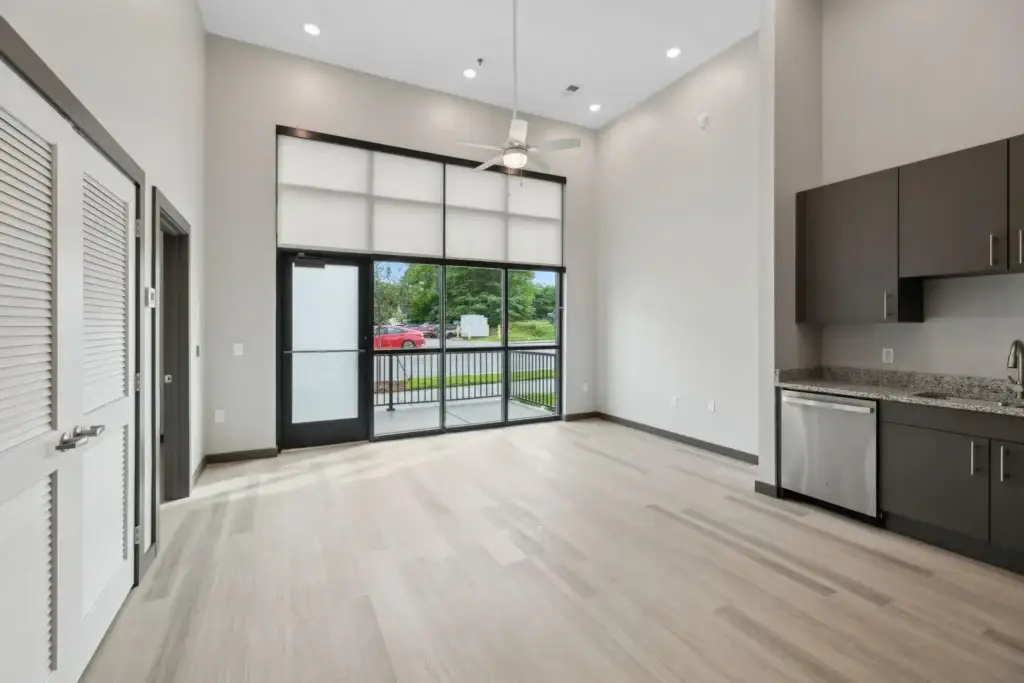 Interior living space and partial kitchen view with 17 ft ceilings and view of outside