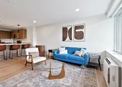 living room furniture and partial kitchen view of west 6th apartments in chattanooga